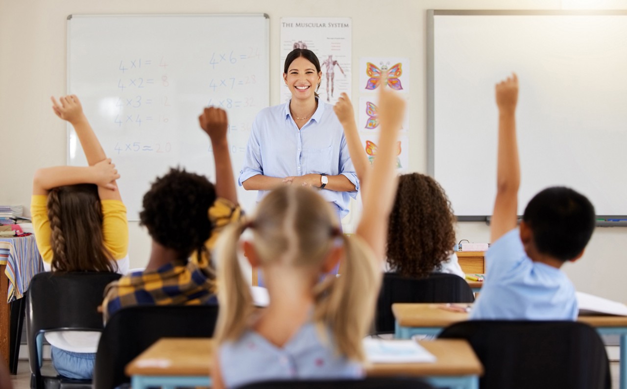 Teacher, hands up or children in classroom learning, exam or studying with preschool notebooks. Development or smart kids or young students with answers, ideas or knowledge in kindergarten or creche.
